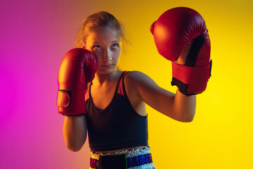 Close up little girl, kick boxer on gradient background in neon light, active and expressive....