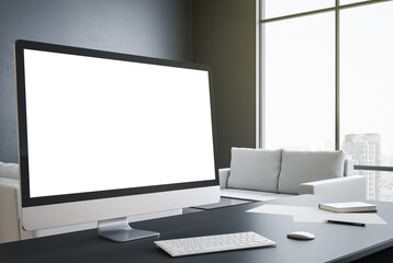 Designer desktop with blank white computer screen