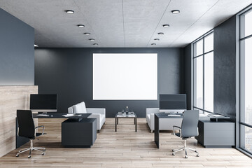 Modern office workspace with blank poster on wall.