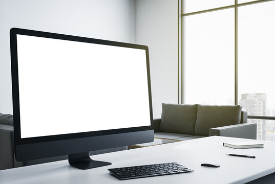Blank white computer screen on designer desktop