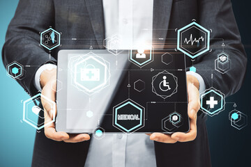 Businessman holding digital tablet with glowing medical interface hud hologram