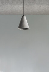 Modern lamp hanging in gray background.
