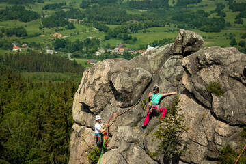 Woman rock climbing near the top with amazing areal view on the surroundings