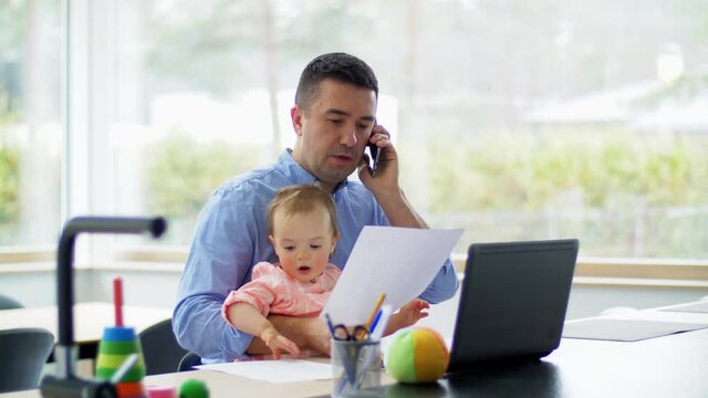 remote job, multi-tasking and family concept - middle-aged father with baby and laptop calling on smartphone at home office