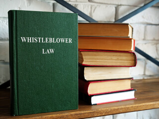 Whistleblower law and a stack of book on a shelf.