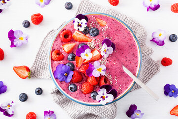 healthy summer berry smoothie bowl with flowers and chia seed