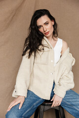 Photo of seductive young woman looking at camera while sitting on chair