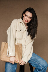 Photo of joyful caucasian woman with bag smiling while sitting on chair