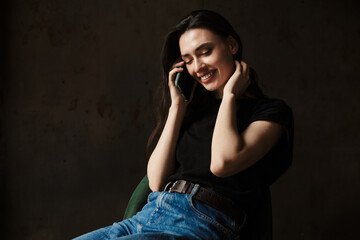 Photo of beautiful woman sitting on chair and talking on cellphone