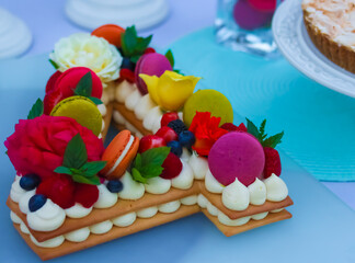 Colorful macarons on a homemade birthday cake shaped like the number 4
