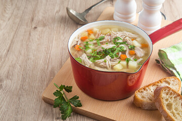 Chicken noodles soup in red pot