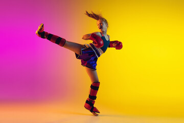 Little caucasian girl, kick boxer on gradient background in neon light, active and expressive. Concept of motion, action, motivation, childhood. Training winner, emotional. Sales, ad, copyspace.