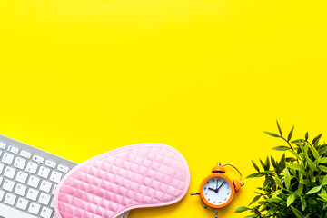 Hard exhausing work. Sleep mask on yellow office desk top-down copy space