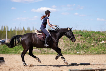 Beautiful girl riding a horse on manege