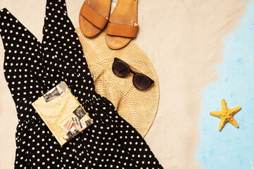 Summer holiday background, flat lay beach women's accessories: dress, straw hat, leather sandals, sun glasses.