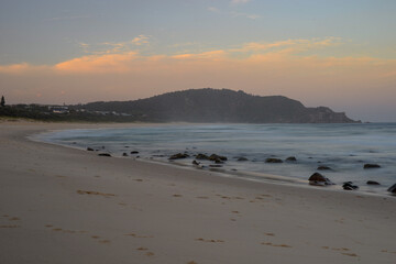 Boomerang Beach sunset looking over the ocean towards the hills