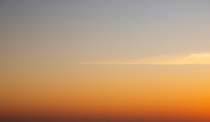 Peaceful golden sunset with one cloud.