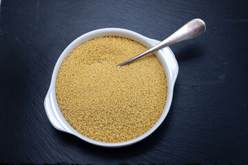 couscous in white bowl on black ceramic background