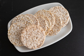 Puffed rice cakes on white dish on ceramic background
