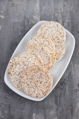 Puffed rice cakes on white dish on ceramic background
