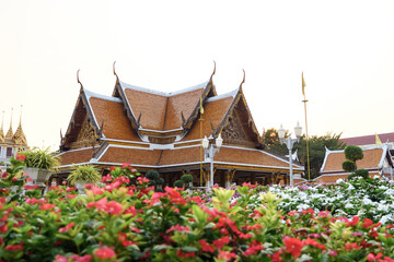 Wat Ratchanatdaram Temple with flowers on foreground in Bangkok, Thailand.
