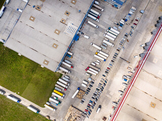 Aerial top view of the large logistics park with warehouse, loading hub with many semi-trailers...