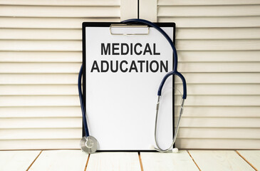 Clipboard with medical education text on a sheet of paper on white background