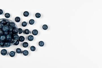 Freshly juicy picked blueberries in glass bowl isolated on white background. 