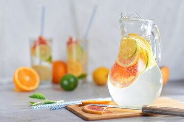 Homemade citrus water with grapefruit, orange, lemon and lime and ice in a jug