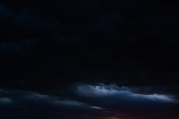 Black thunderclouds at sunset. Bright orange sunset and dark clouds. Storm sky