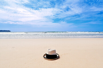 Fototapeta na wymiar sun hat dropped on the clear and clean white sand beach in tropical island Phuket thailand
