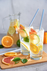 Homemade citrus water with grapefruit, orange, lemon and lime and ice in glass