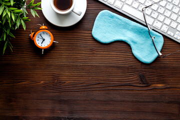 Sleeping on office desk. Concept with sleep mask and laptop top-down copy space