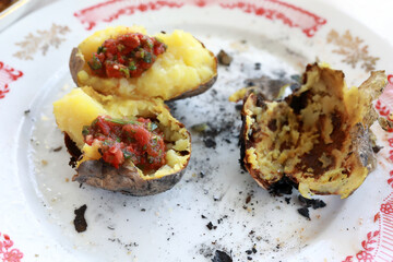 Plate with leftovers of charcoal baked potatoes