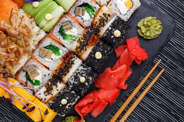 Different types of asian sushi rolls on gray background. Close up top view.