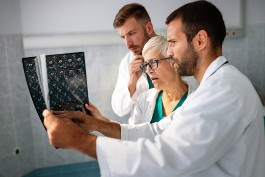 Group of doctor looking at ct scan at hospital to make diagnosis