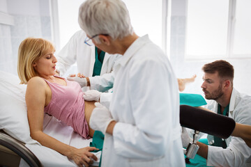 Obraz premium In the hospital woman in labor pushes to give birth, obstetricians assisting