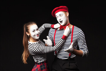a man and a woman with white makeup on their faces like mimes  with funny emotions isolated on...