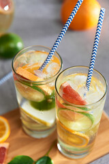 Homemade citrus water with grapefruit, orange, lemon and lime and ice in glass