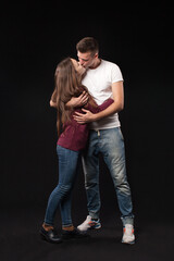 Smiling happy loving couple in studio on black background 