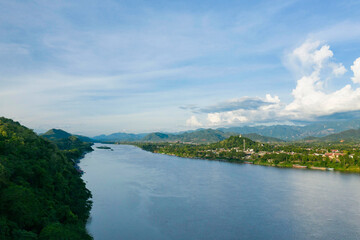 Fototapeta na wymiar Une ville au bord du fleuve Mékong entouré de montagnes vers Luang Prabang, au Laos.
