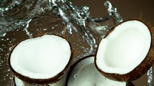 Super slow motion of coconut pieces flying in the air with water splashes. Filmed on high speed cinema camera, 1000 fps.