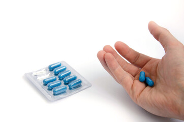 Blue capsules on a white background close up.