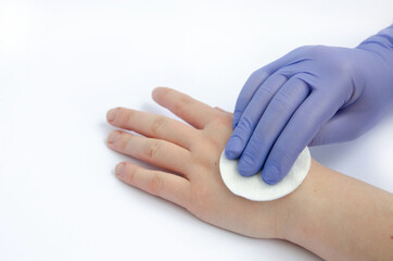 wiping hands with a cotton pad in gloves on a white background