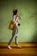 Tourist in a denim jacket and hat with a camera and bag. Happy emotions