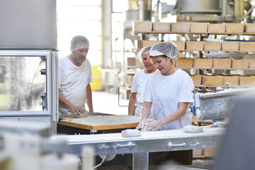 Worker in a large bakery - industrial production of bakery products on an assembly line