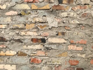 background texture wall of bricks of different colors and shapes with lots of cement