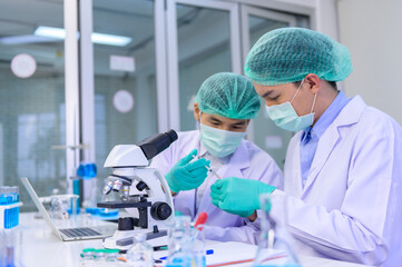 Scientist team has researching Coronavirus cure in the laboratory. Asian Doctor working on vaccine...