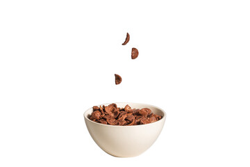 Chocolate corn flakes falling to the white bowl isolated on white. Motion.