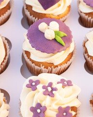 Closeup of tasty homemade cupcakes with sugar icing in paper box.